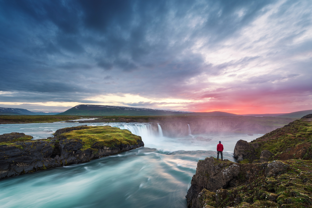 person standing at Godafoss Waterfall