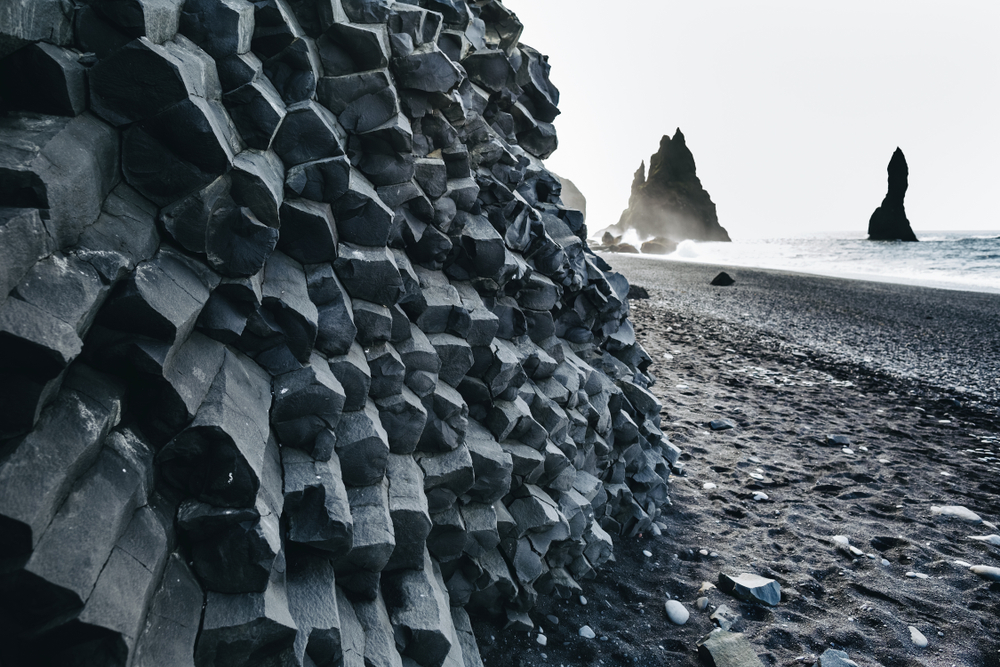 Reynisfjara black sand beach with basalt in foreground and ocean in background