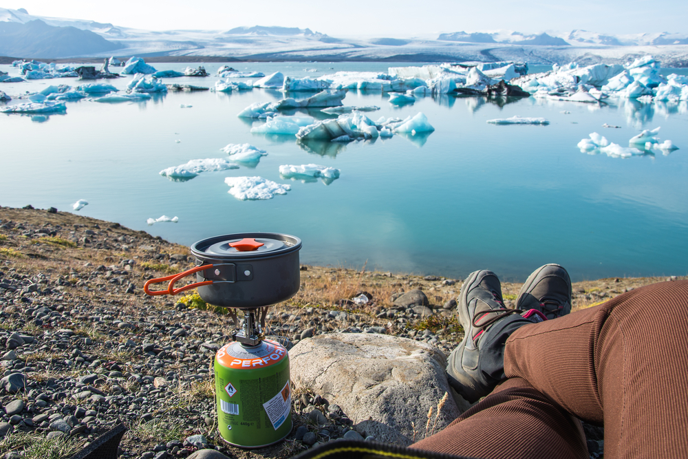 Camping in Iceland with a camp stove near glacial lagoon.