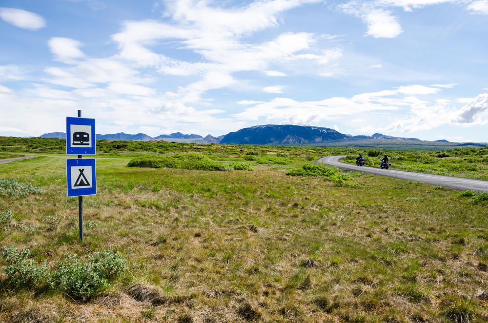 Landscape with road sign for camping in Iceland.