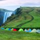 A line of tents for camping in Iceland near the Skogafoss Waterfall.