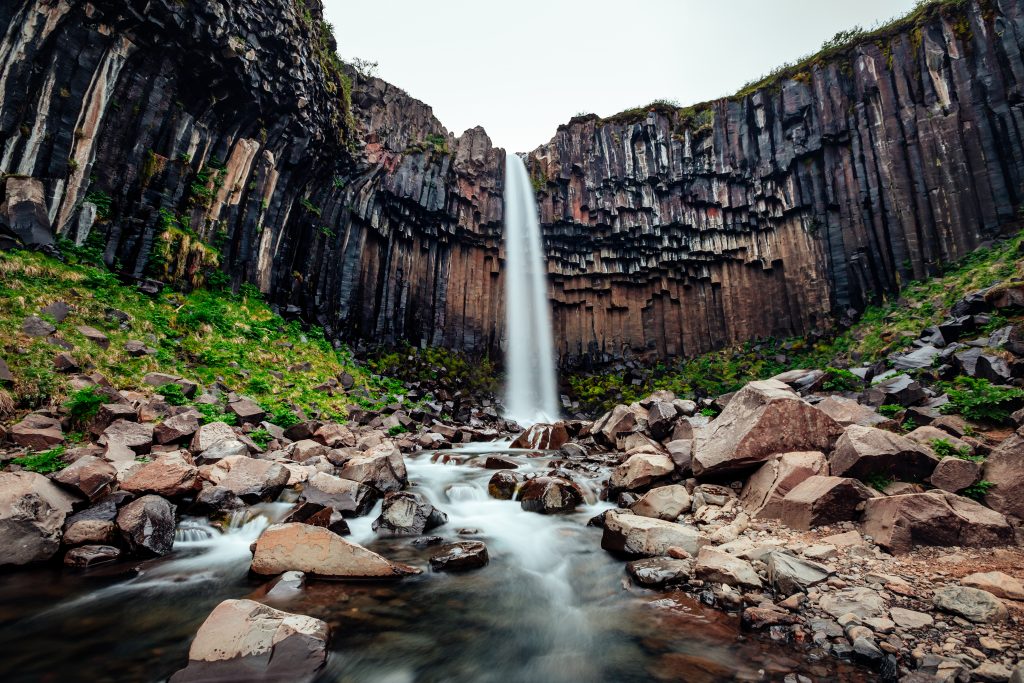 waterfall surrounded by basalt columns Iceland Itinerary