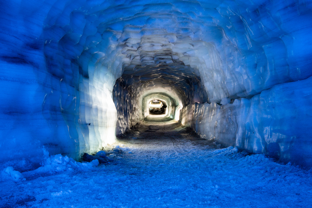 a view of long corridor of blue ice in an ice cave