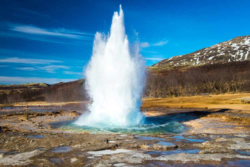 Reykjavik Day Trips a geyser blasting water high into the sky on a sunny day