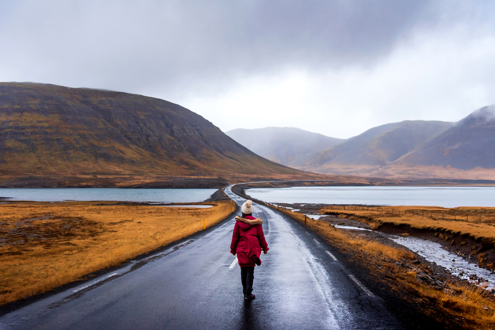Photo of a girl on a road. Summer is the best time to visit Iceland to explore.
