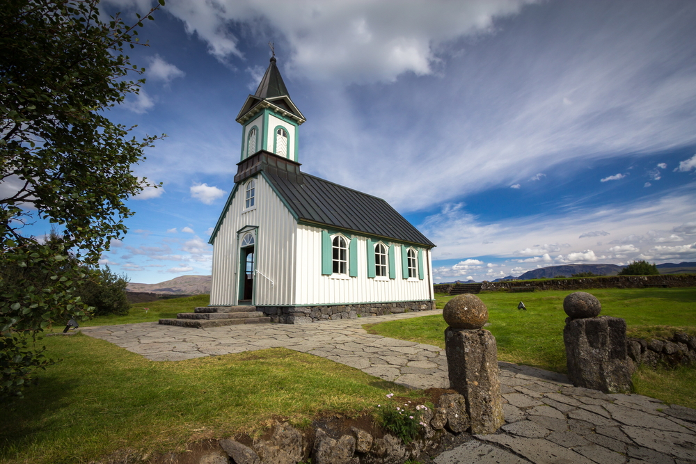 a white and blue icelandic church located in Thingvellir national park