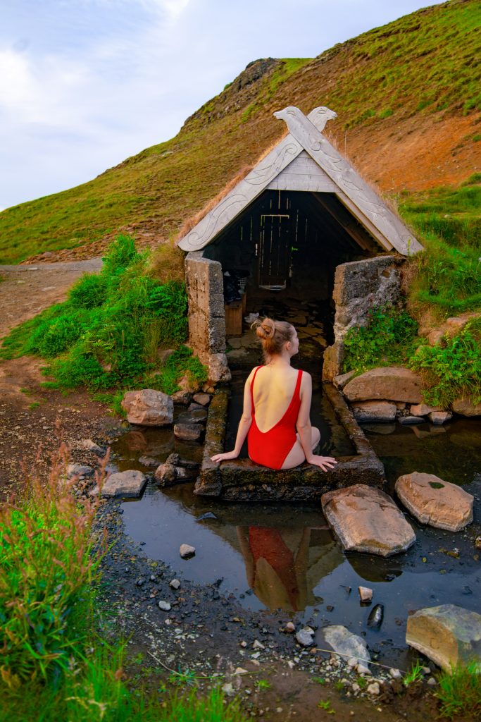 woman sitting in red swimsuit in a hot spring in iceland