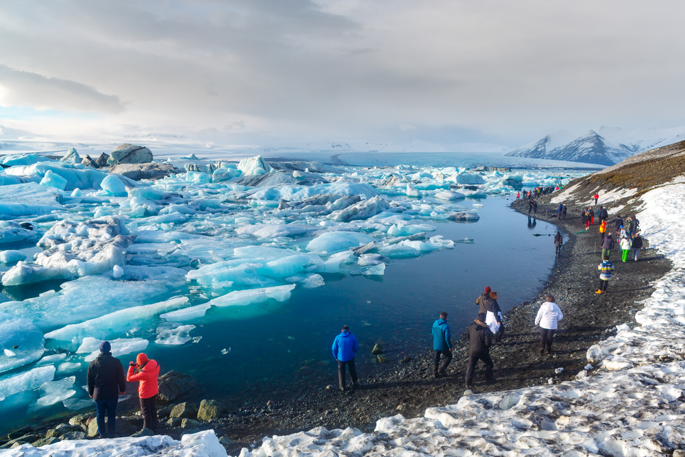 People walking on the shore at jokulsarlon glacier lagoon 