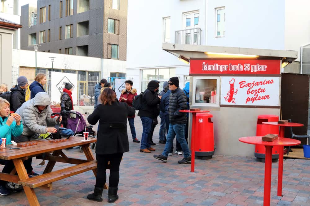 people gathered around a hotdog stand in Iceland