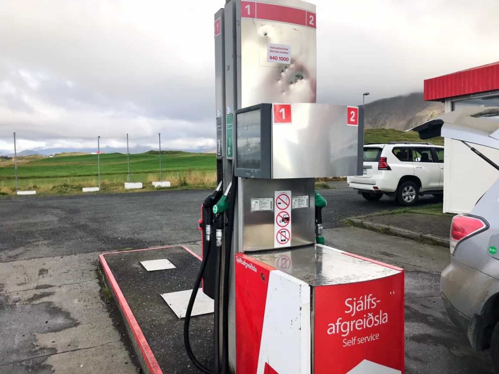 a gas station pump with moody landscape in the background