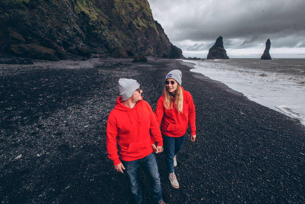 Photo of couple at one of Iceland's famous black sand beaches.