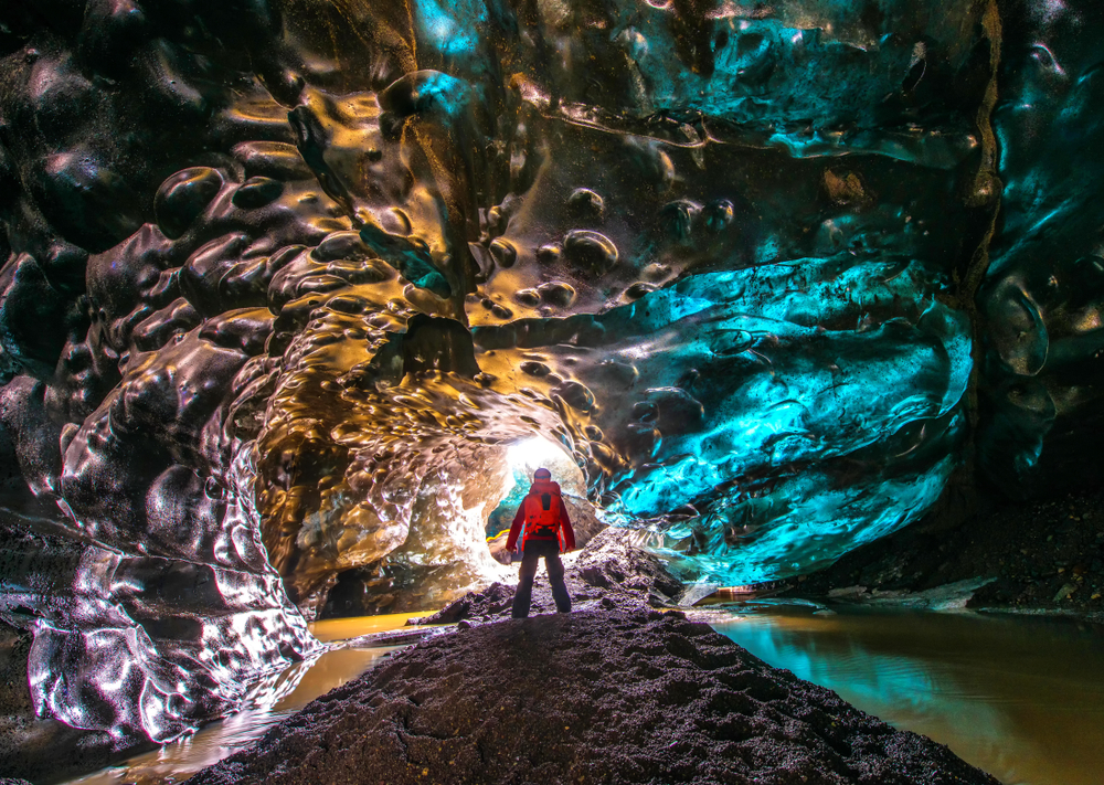 photo of a hiker inside an ice cave, one of the many activities you can do in a national park in iceland