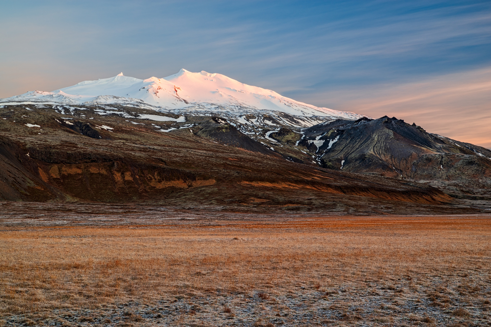 photo of the Snaefellsjokull mountain. There is snow on the top of it.