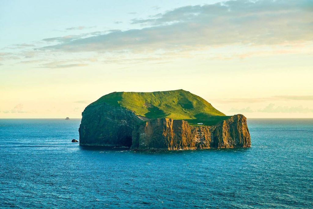 small house on westman island in iceland at sunset