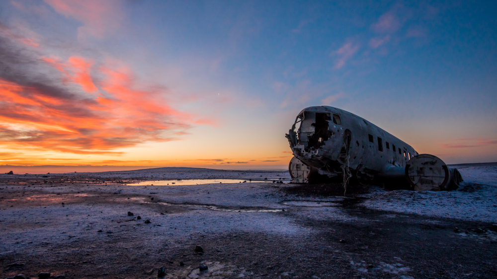 The famous plane wreck at Solheimasandur Beach in Iceland at sunset with snow on the ground