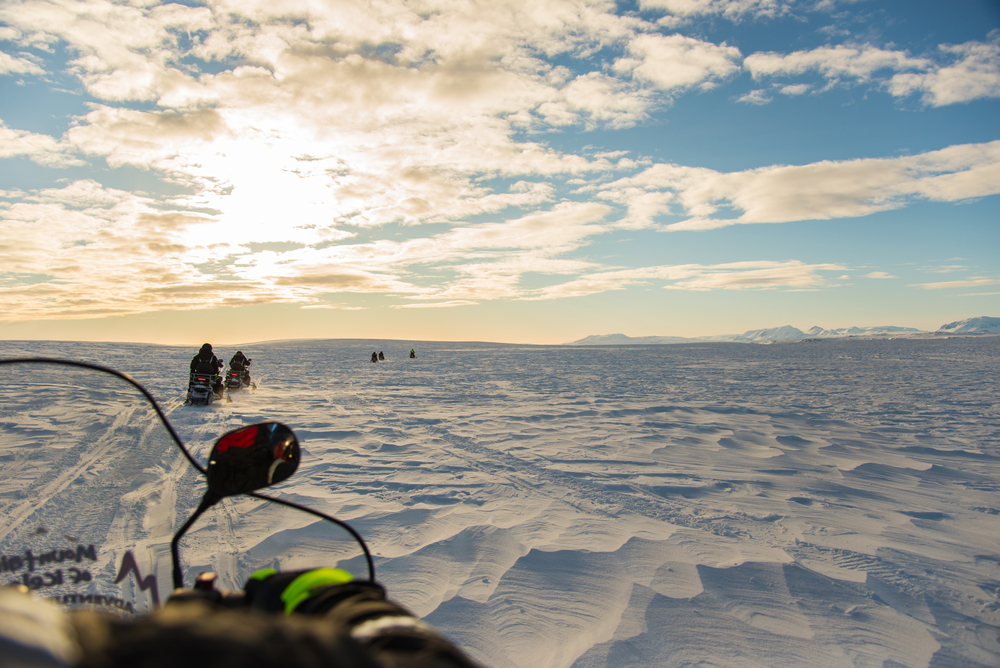 People riding snowmobiles on Langjökull Glacier in iceland