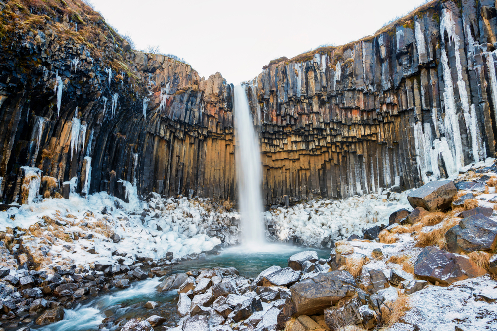 Waterfall surrounded by basalt rocks in Iceland in the winter