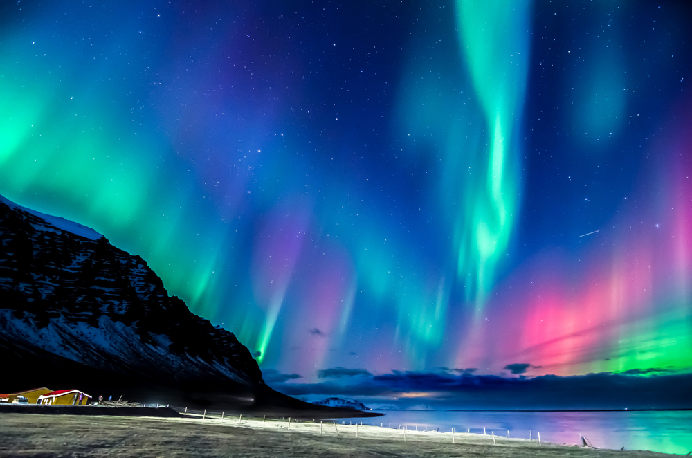 The Northern Lights dancing in the sky over snowy landscape