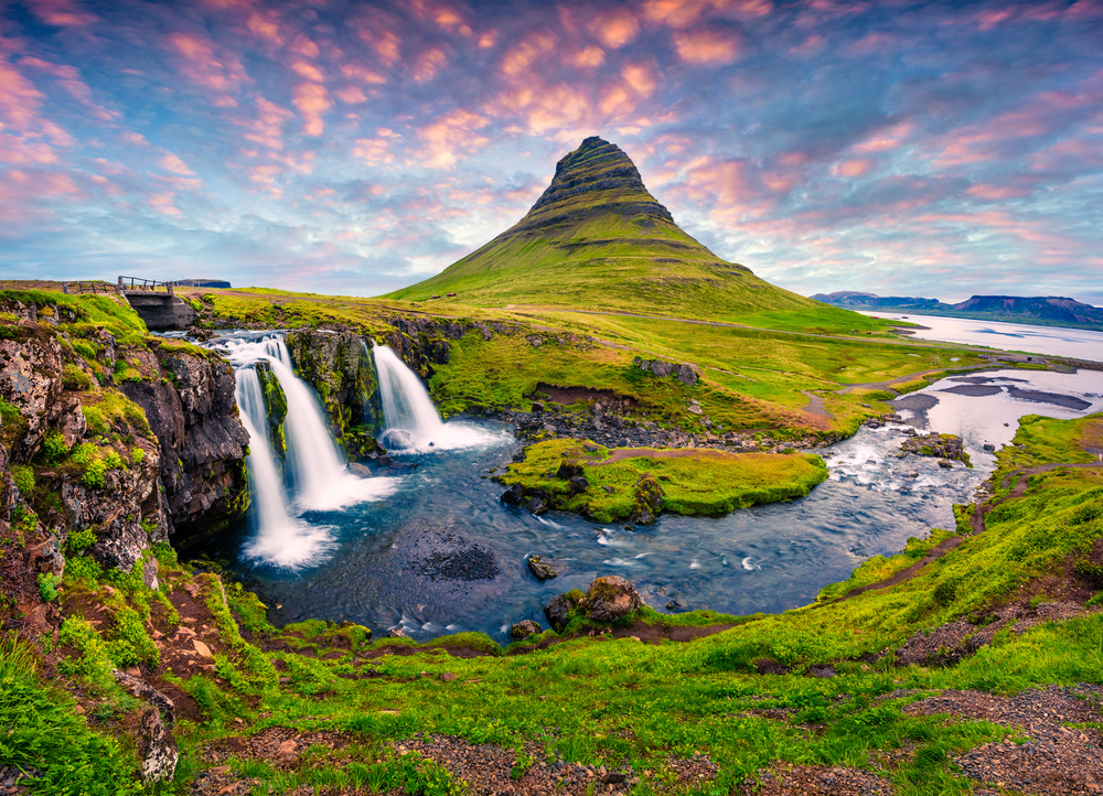 Kirkjufellsfoss Waterfall with Kirkjufell Mountain in the distance.