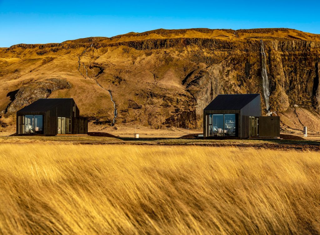 Black cottages in open field airbnbs in iceland best vacation rentals in iceland