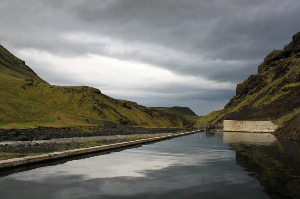 remote swimming pool in iceland with river next to it
