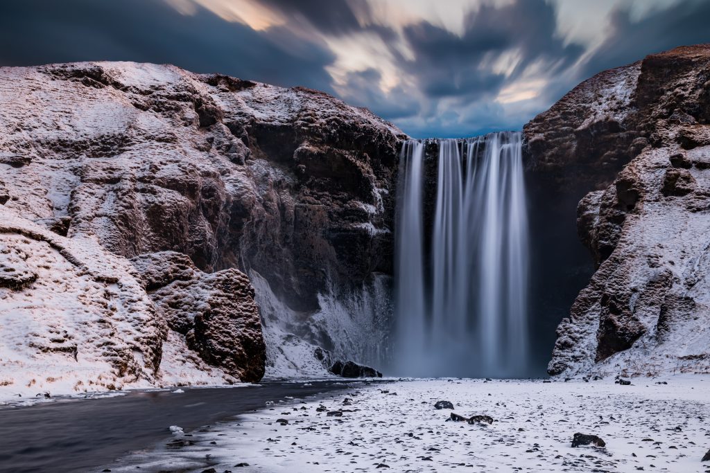 skogafoss waterfall covered in snow on a moody winter day