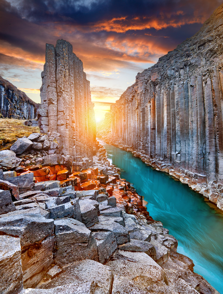 River flowing through the black basalt columns of Studlagil Canyon hidden gem in Iceland