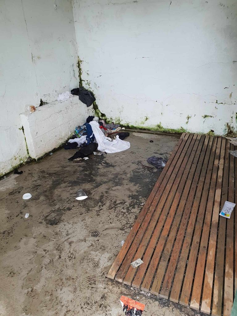 wet nasty clothes and trash in one of the changing rooms at Seljavallalaug pool