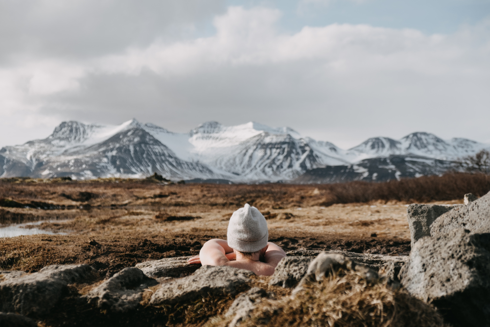 person sitting in Landbrotalaug hot spring on Iceland's Snaefellsnes Peninsula