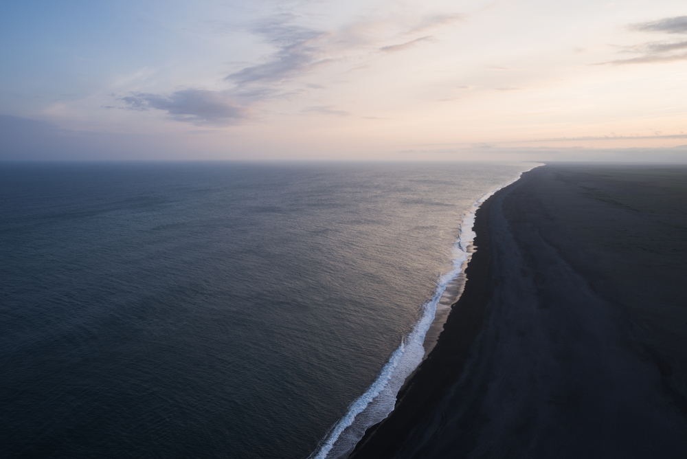 overlooking a black sand beach in iceland at sunset