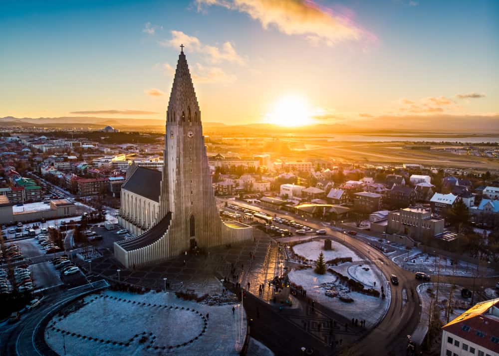 aerial shot of a large church in the center of Reykjavik at sunset with some snow on the ground in Iceland in November