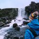 person standing in front of waterfall in iceland in november