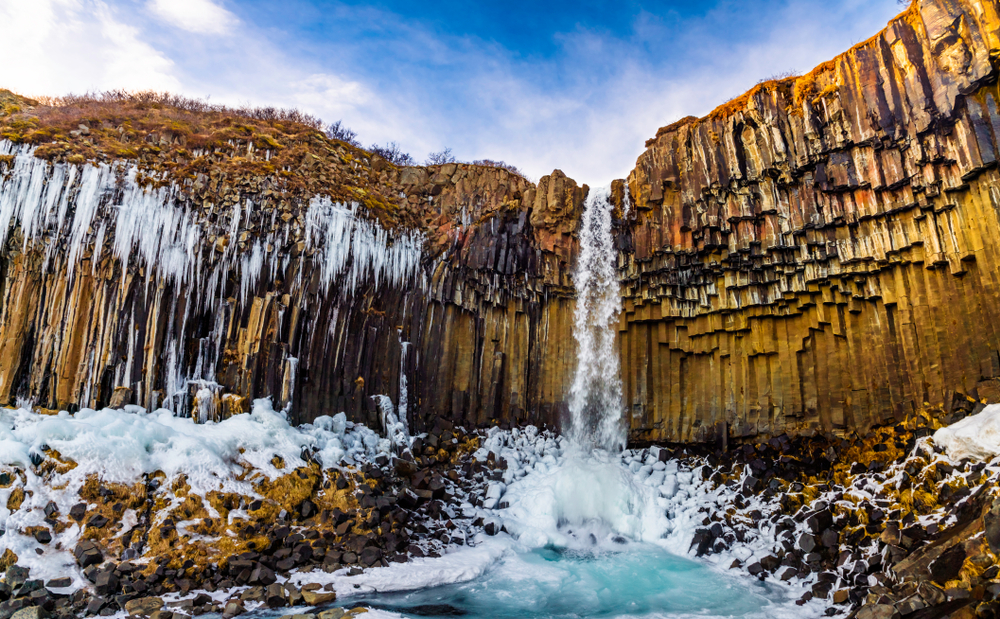 svartifoss waterfall with melting snow during iceland in march