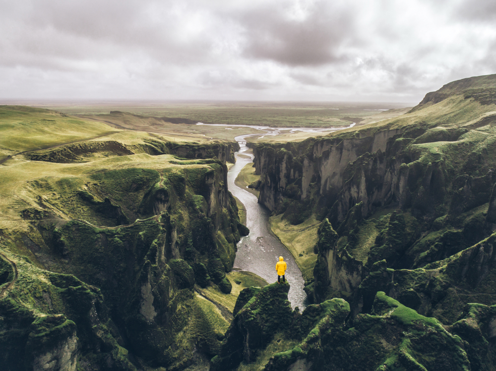 a tourist standing at the edge of Fjadrargljufur Canyon