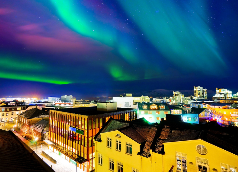 Northern Lights in Reykjavik over the buildings in the heart of the city
