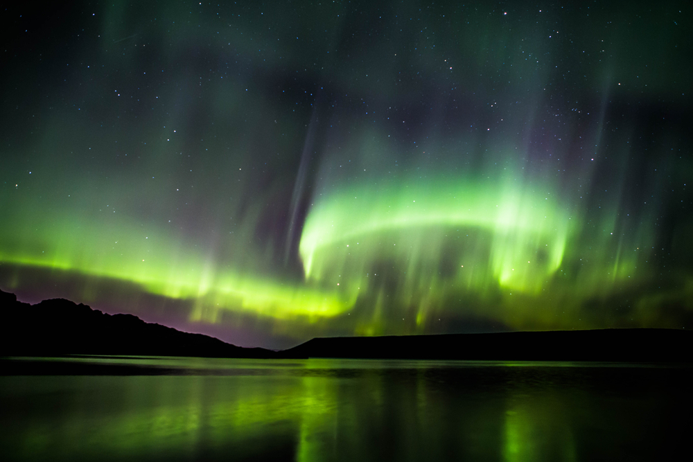 the Northern Lights dancing overhead and reflected in the waters of Lake Kleifarvatn
