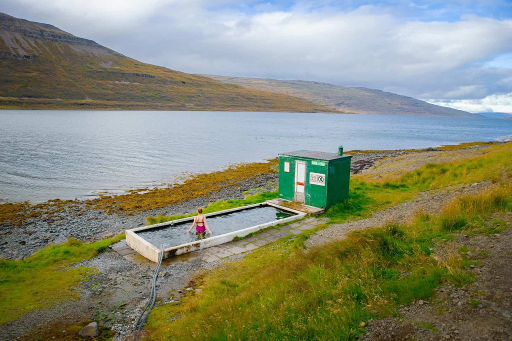 woman sitting in hotspring on a moody day in the westfjords