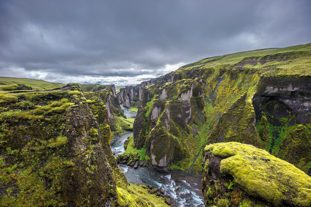 Iceland-Canyon Fjadrargljufur Canyon with mossy hills and river running through bottom