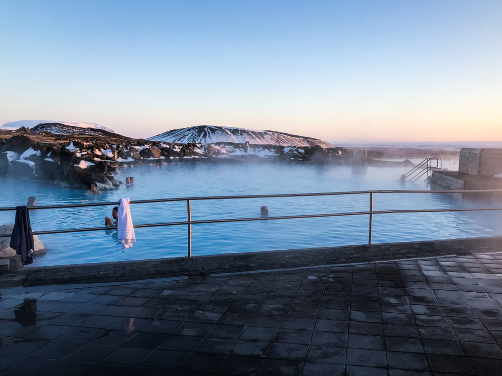 Families swim in the Myvatn Nature baths next to the snowy landscape of Iceland