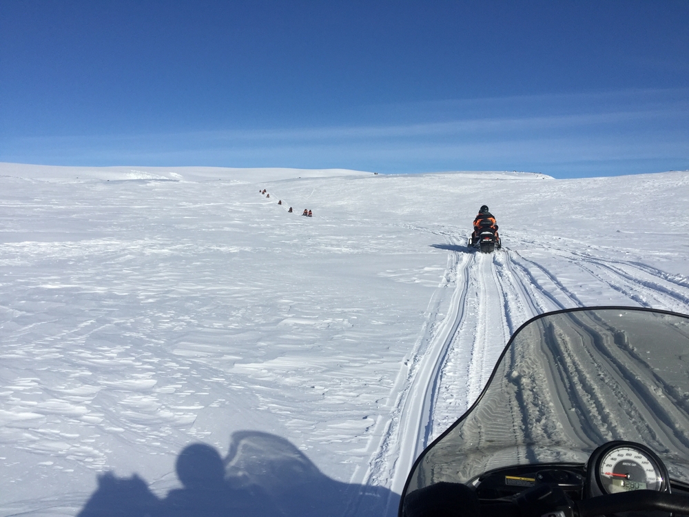 A snowmobiling tour in Iceland going over an expense of snow.