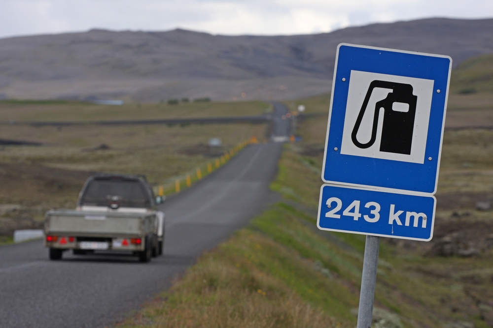 a sign on the road in Iceland indicating that the next gas station is 243 km away