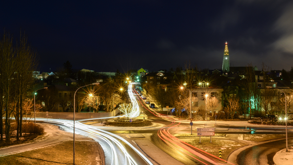 a roundabout in Reykjavik, Iceland at night time with white and red streaks indicating the cars driving through