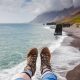 feet wearing the best boots for iceland over a black sand beach with moody clouds