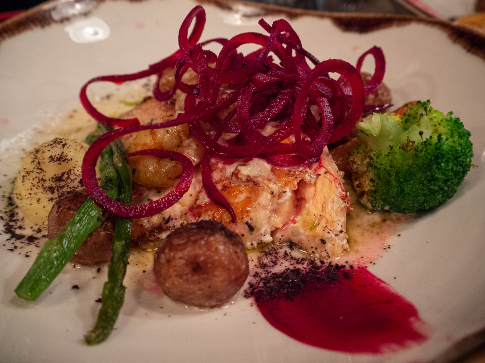 Salmon and vegetables on a plate with pickled beetroot on top