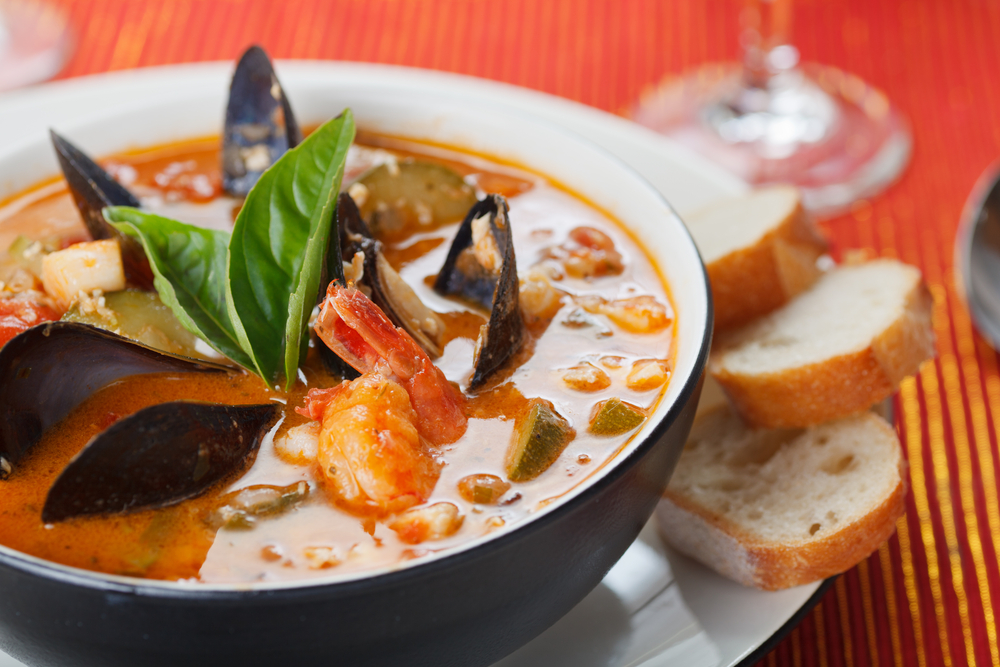 Bowl of fresh seafood soup on a table with bed in an article about restaurants in Iceland