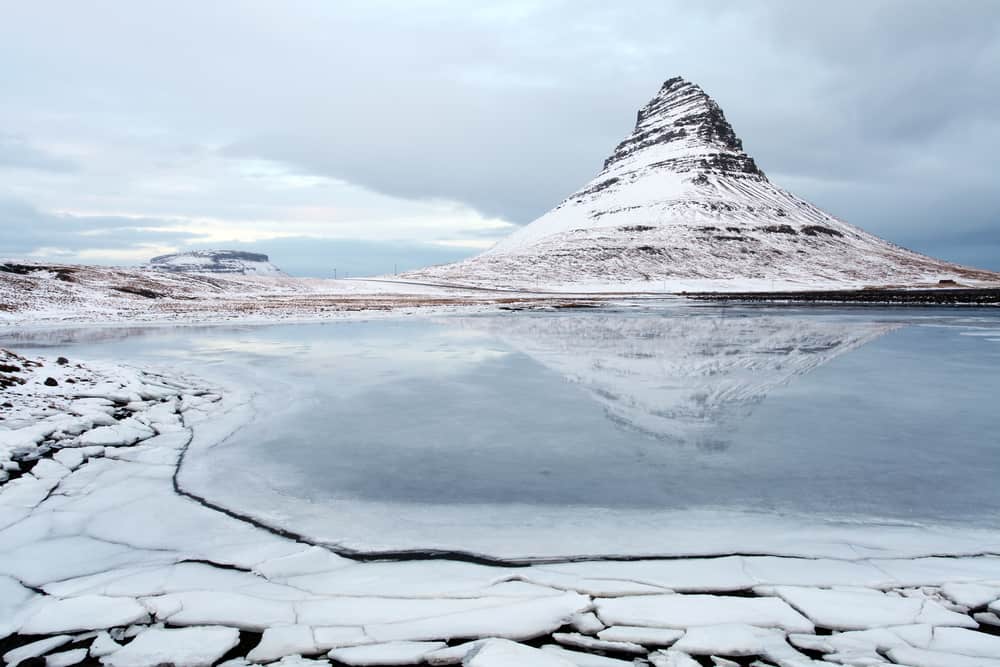 Kirkjufell Mountain with its reflection in ice on a moody winter day