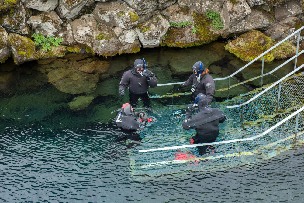 A group of divers gather at the launch pad of the fissure, ready to begin their silfra snorkeling tour