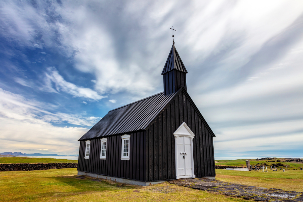 this black church is a strong contrast to the blue skies and green grass in Iceland.