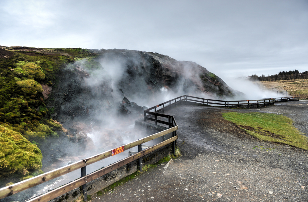 A wooden barrier protects visitors from the steam and heat of a hot spring.