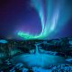northern lights over waterfall in iceland in February